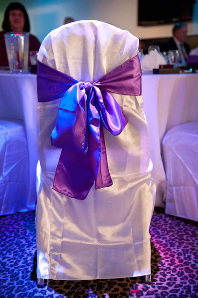 purple bow on a white linen lined chair